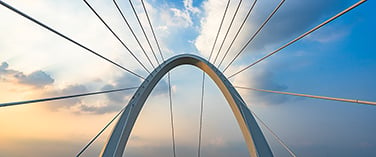 Close-up view of a modern arch bridge with suspension cables