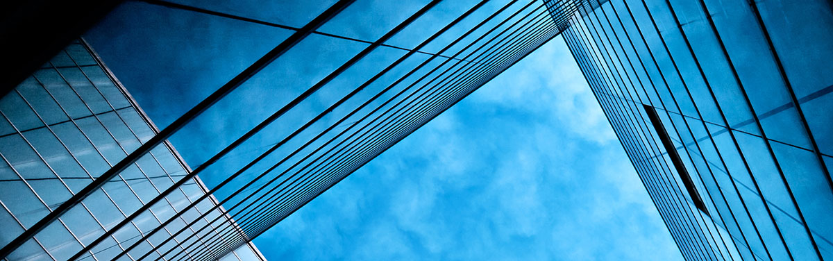 ow angle shot looking directly up at the blue sky above an office building 