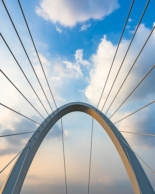 Close-up view of a modern arch bridge with suspension cables