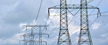 Tall metal electricity pylons against a cloudy sky